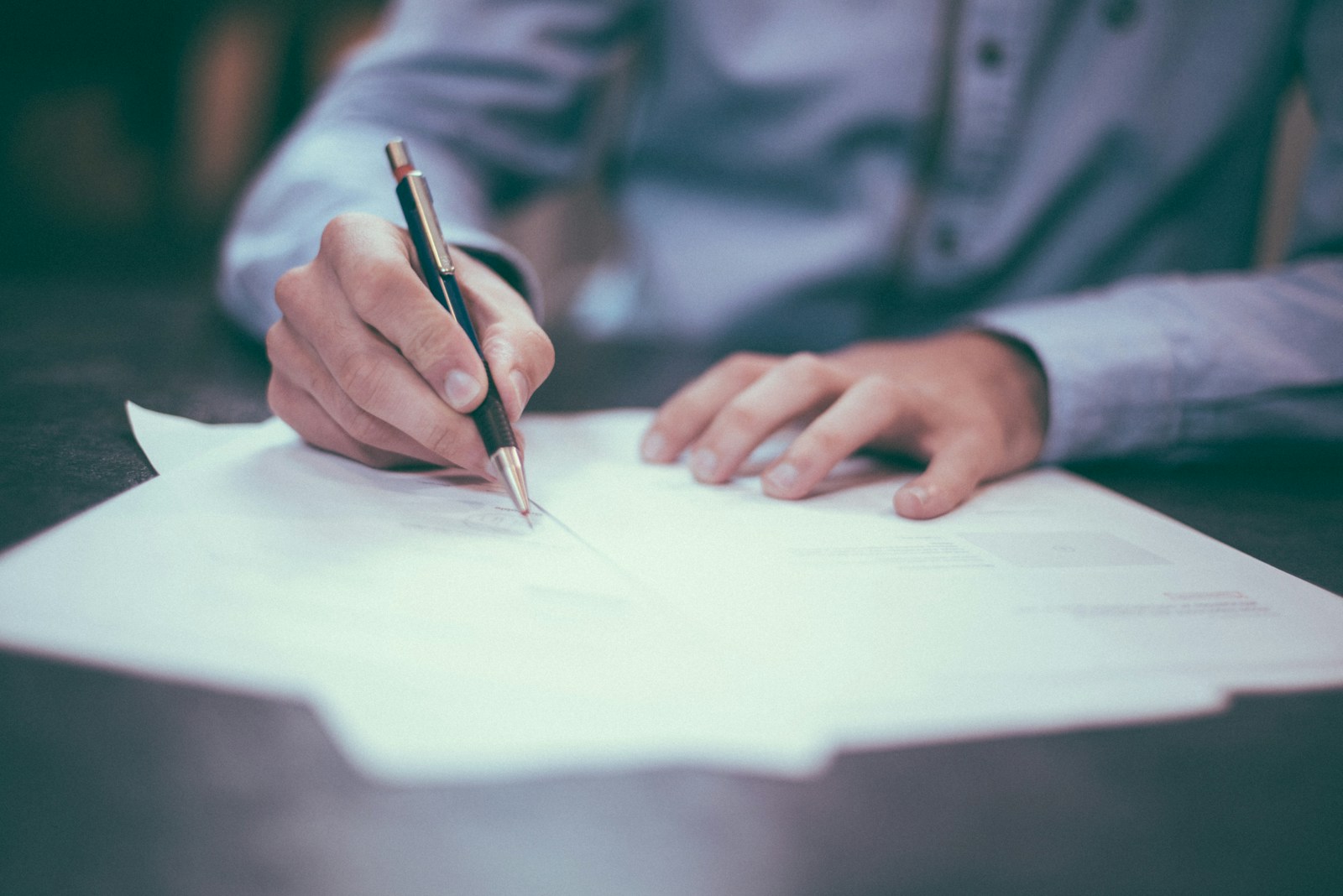 man writing on paper, insurance policies